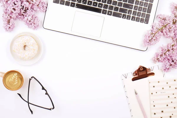 Top view of female worker desktop with laptop, flowers and different office supplies items. Feminine creative design workspace. — Stock Photo, Image