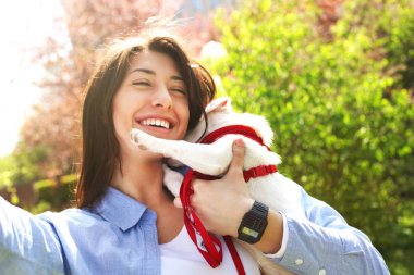 Güzel genç kadın selfie ile şirin ona jack russell terrier köpek park, yeşil çim ve yeşillik arka plan piknik üzerinde alır. Kadın sahibi ve küçük evde beslenen hayvan, komik köpek. Yakın çekim, alanı Kopyala
