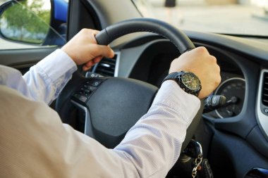 Yumuşak günbatımı ışık direksiyonuna oturan erkek Şoförlü araba iç. Lüks araç kontrol paneli ve elektronik.