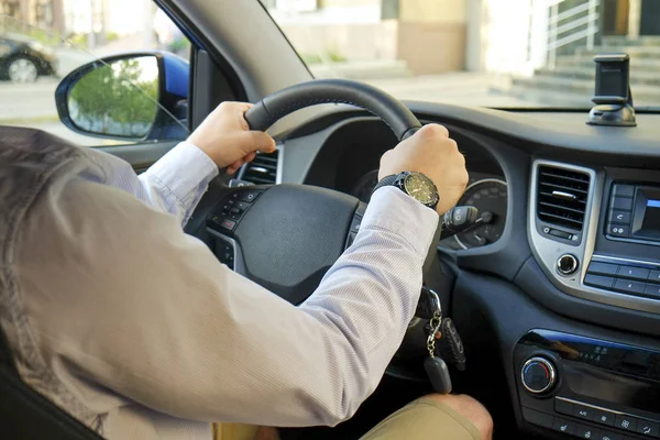 Autoinnenraum mit männlichem Fahrer am Steuer, weiches Sonnenuntergangslicht. luxuriöses Armaturenbrett und Elektronik. — Stockfoto