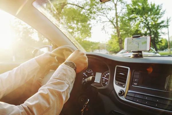 Autoinnenraum mit männlichem Fahrer am Steuer, weiches Sonnenuntergangslicht. luxuriöses Armaturenbrett und Elektronik. — Stockfoto