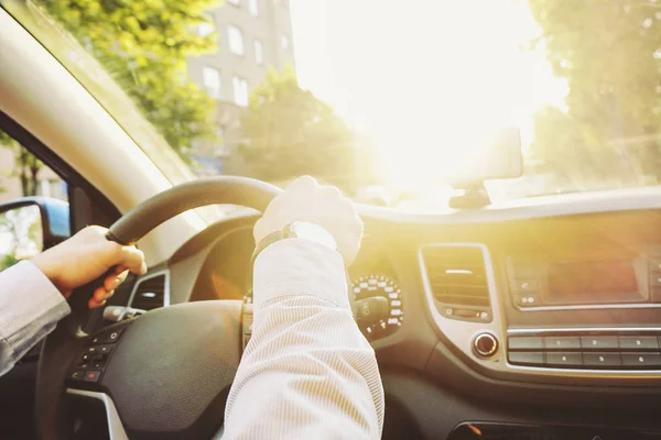 Interior del coche con conductor masculino sentado detrás del volante, luz suave puesta del sol. Tablero de instrumentos y electrónica de lujo para vehículos . — Foto de Stock