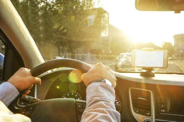 Autoinnenraum mit männlichem Fahrer am Steuer, weiches Sonnenuntergangslicht. luxuriöses Armaturenbrett und Elektronik. — Stockfoto