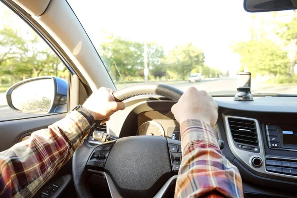 Autoinnenraum mit männlichem Fahrer am Steuer, weiches Sonnenuntergangslicht. luxuriöses Armaturenbrett und Elektronik. — Stockfoto