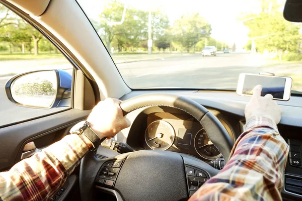 Autoinnenraum mit männlichem Fahrer am Steuer, weiches Sonnenuntergangslicht. luxuriöses Armaturenbrett und Elektronik. — Stockfoto