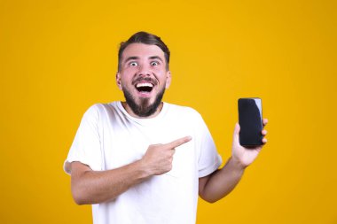 Mükemmel bakımlı sakallı adam, sarı arka planda şık bir saç stili var..