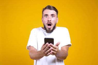 Mükemmel bakımlı sakallı adam, sarı arka planda şık bir saç stili var..