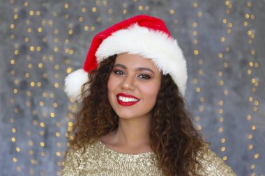 Güzel siyahi kadın dekoratif ışıklarla duvarda poz veriyor..