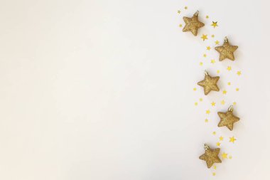 Noel konsepti. Düzenli kompozisyon, geleneksel şenlik nitelikleri, altın yıldız şekilli ağaç süslemeleri. Kış tatili sezonu. Arkaplan, boşluğu kopyala, kapat, üst görünüm, düz yat.