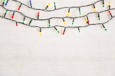 Noel konsepti. Yeni yıl dekorasyon ışıkları, grunted ahşap masa üzerinde farklı renkte bir sürü küçük lamba bulunan çelenkler. Üst görünüm, düz görünüm, kopyalama alanı.