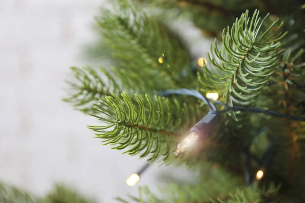 Tradicional pino de Navidad con decoraciones navideñas, espacio de copia para el texto. Luces decorativas que brillan sobre el abeto. Primer plano, fondo, interior. — Foto de Stock