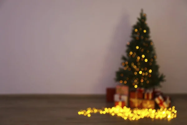 Pohon pinus Natal tradisional dengan dekorasi liburan, salinan ruang untuk teks. Lampu hias menyala di cemara. Tutup, latar belakang, interior. — Stok Foto