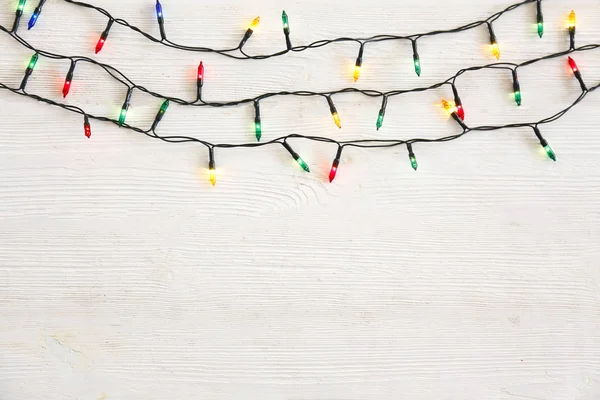 Noel konsepti. Yeni yıl dekorasyon ışıkları, grunted ahşap masa üzerinde farklı renkte bir sürü küçük lamba bulunan çelenkler. Üst görünüm, düz görünüm, kopyalama alanı.