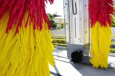 Benzin istasyonunda boş oto yıkama servisi. Renkli kırmızı ve sarı dönen araba yıkama fırçaları. Kapat, kopyala boşluk, arkaplan.