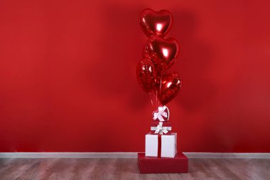 Kalp şeklinde helyum şişirilmiş kırmızı folyo hava balonu havada uçuşuyor..