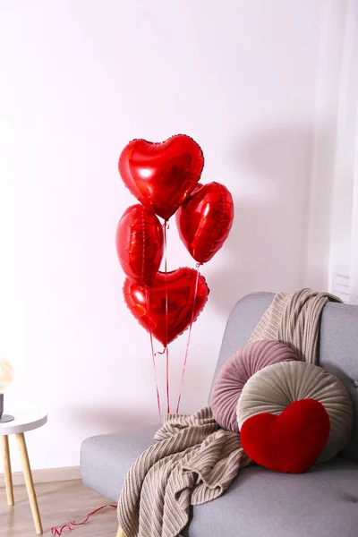 Herzförmiger Helium aufgeblasener roter Folienluftballon fliegt in der Luft. — Stockfoto