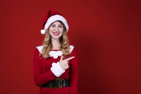 Glimlachende vrouw dragen feestelijke outfit op rode muur achtergrond. — Stockfoto