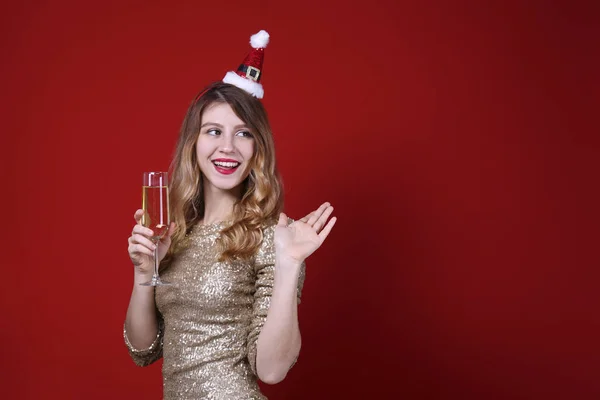 Sorrindo mulher vestindo roupas comemorativas no fundo da parede vermelha . — Fotografia de Stock