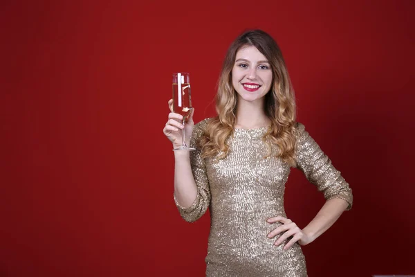 Glimlachende vrouw dragen feestelijke outfit op rode muur achtergrond. — Stockfoto