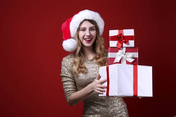 Smiling woman wearing celebratory outfit on red wall background. — Stock Photo, Image