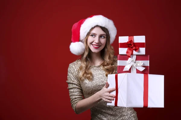 Smiling woman wearing celebratory outfit on red wall background. — Stock Photo, Image