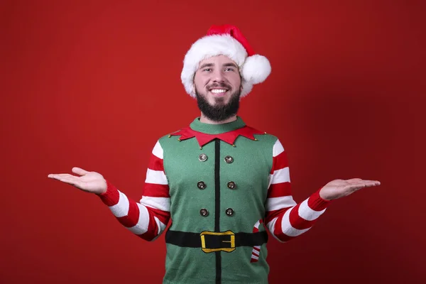 Молодий чоловік з ідеально дорослою бородою на різдвяному вбранні на фоні червоної стіни . — стокове фото