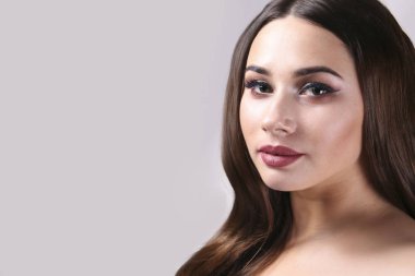 Makyajını gösteren esmer saçlı kadın portresi..