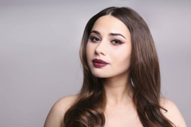 Makyajını gösteren esmer saçlı kadın portresi..