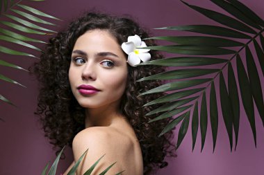 Hafif makyajlı, kıvırcık saçlı, omuzsuz elbiseli güzel bir kadın..