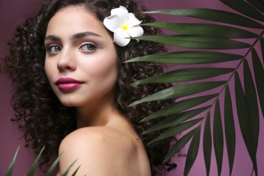 Hafif makyajlı, kıvırcık saçlı, omuzsuz elbiseli güzel bir kadın..