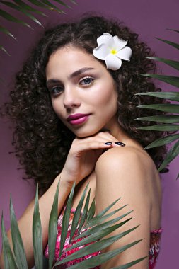 Hafif makyajlı, kıvırcık saçlı, omuzsuz elbiseli güzel bir kadın..