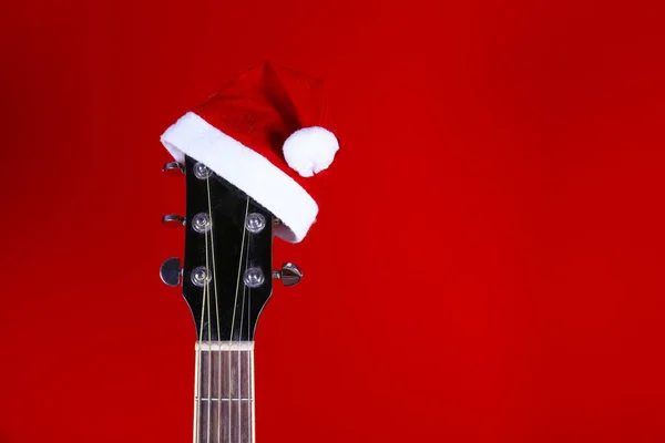Christmas music concept. Acoustic guitar with steel strings and santa claus hat.