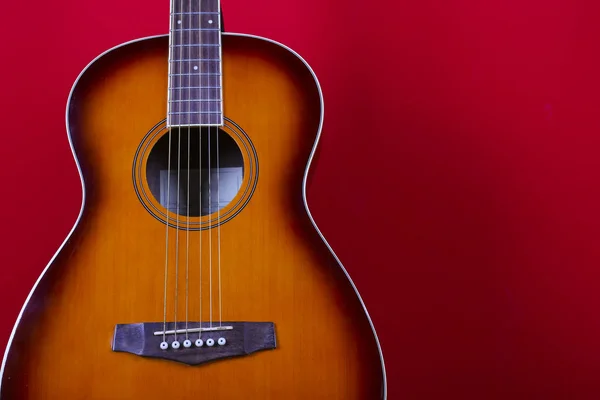 Kırmızı duvar arka planında altı telli halk akustik gitarı.. — Stok fotoğraf