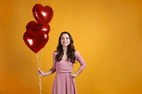 Hermosa hembra sosteniendo globos flotantes para las vacaciones de San Valentín . — Foto de Stock