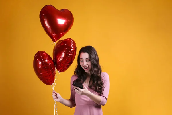 Hermosa hembra sosteniendo globos flotantes para las vacaciones de San Valentín . — Foto de Stock