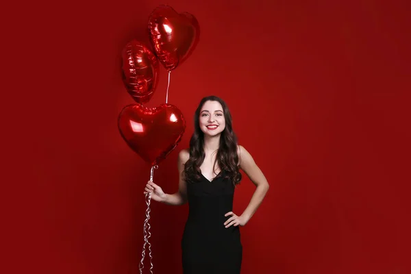 Hermosa hembra sosteniendo globos flotantes para las vacaciones de San Valentín . — Foto de Stock