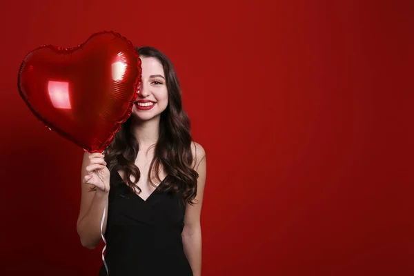 Hermosa hembra sosteniendo globos flotantes para las vacaciones de San Valentín . — Foto de Stock