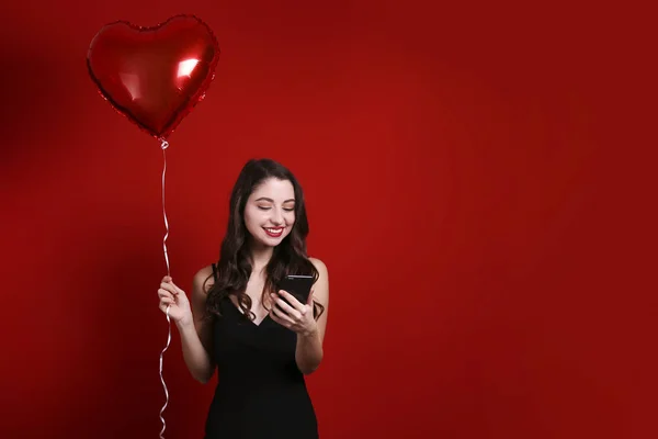 Hermosa hembra sosteniendo globos flotantes para las vacaciones de San Valentín . — Foto de Stock
