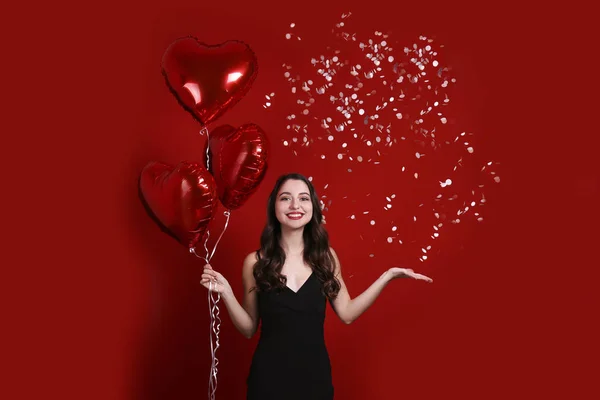 Hermosa hembra sosteniendo globos flotantes para las vacaciones de San Valentín . — Foto de Stock