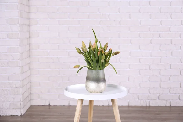 Appartamento vuoto con interni in stile loft minimale, pavimento in legno e vaso di vetro con bouquet di tulipani su parete in primo piano e vuota con molto spazio per copiare il testo sullo sfondo. Da vicino. . — Foto Stock