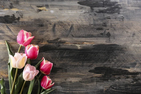 Frühlingsblumenstrauß auf strukturiertem Tischhintergrund mit viel Textfläche. Draufsicht, Nahaufnahme, flache Liegekomposition. — Stockfoto