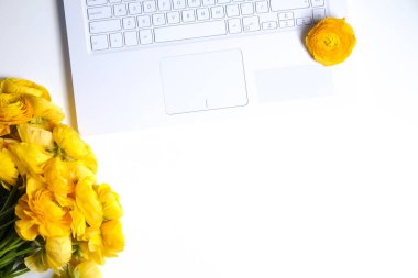 Dizüstü bilgisayarın klavyesinin üst görüntüsü ve desenli masa üzerindeki metin için bir sürü fotokopi alanı olan bir buket çiçek. Desenli tablo arkaplanı.