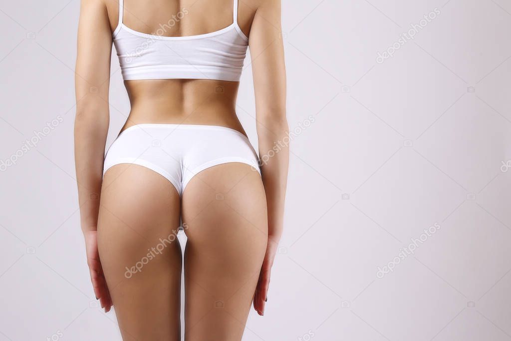 Cropped image of a sporty female in white bra and high waisted panties.