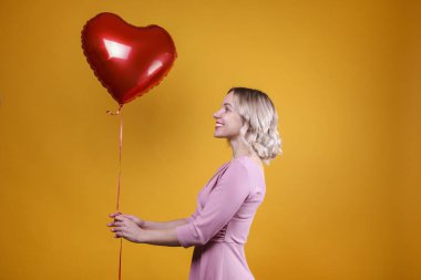 Omuz hizasında, dalgalı saçlı, balon tutan hoş bir kadın..