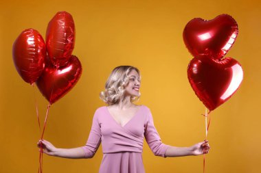 Omuz hizasında, dalgalı saçlı, balon tutan hoş bir kadın..