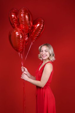 Omuz hizasında, dalgalı saçlı, balon tutan hoş bir kadın..