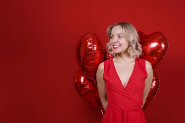 Omuz hizasında, dalgalı saçlı, balon tutan hoş bir kadın..