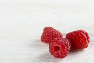 Sweet raspberry scattered on textured background with text space.