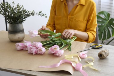 Cropped shot of a woman arranging bouquet of flowers.
