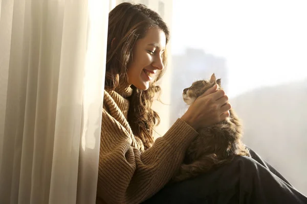 Харизматичная молодая женщина играет со своим очаровательным котом . — стоковое фото